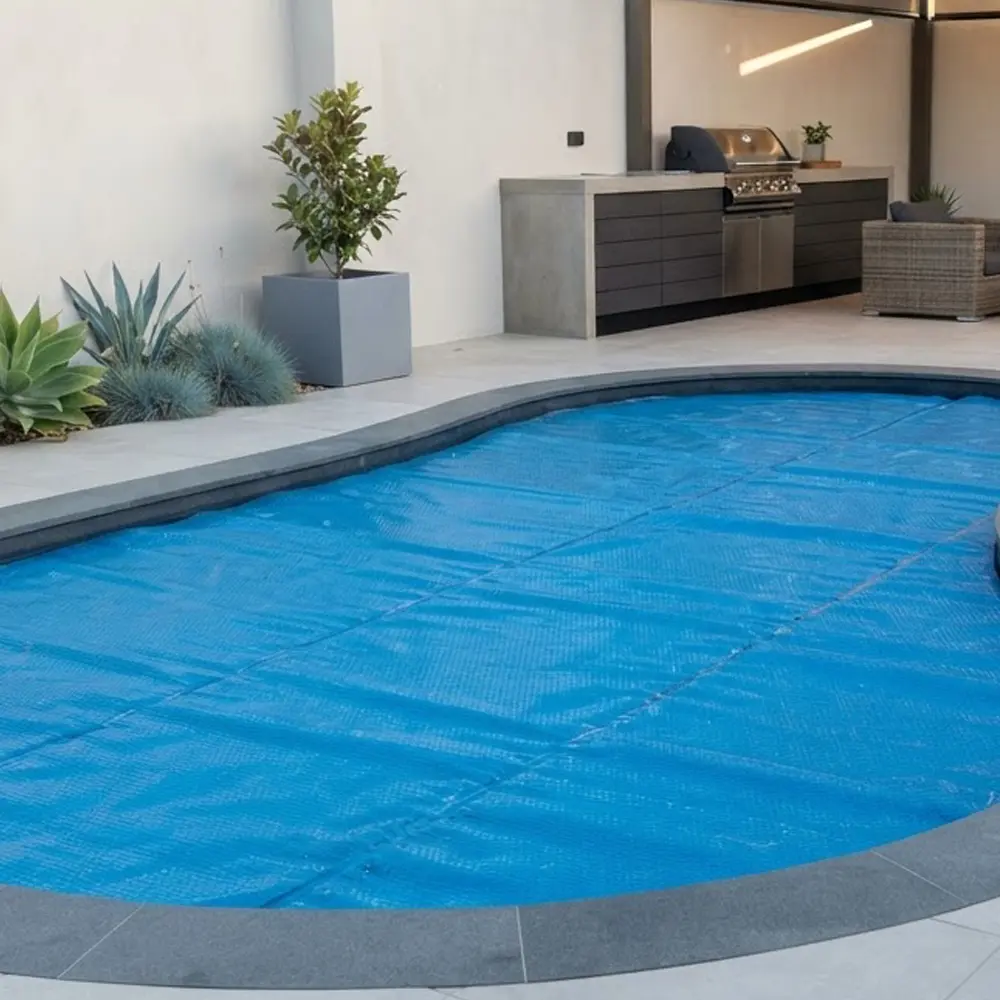 Solar pool cover fitted over a residential swimming pool